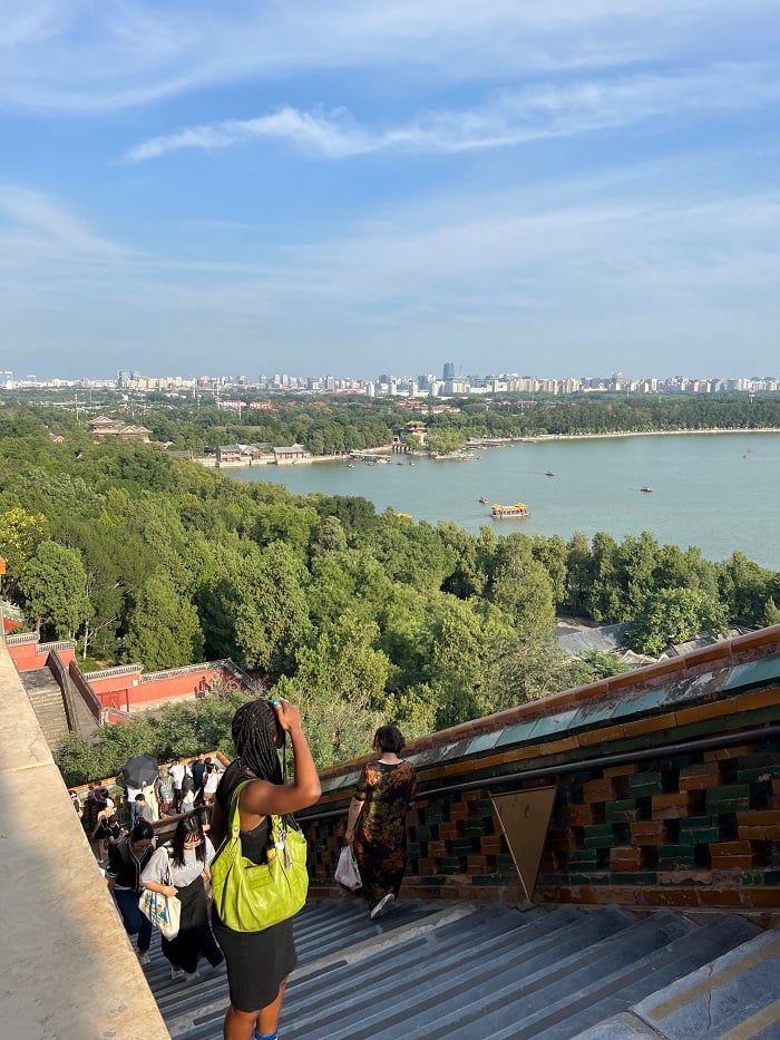 People looking out over the Summer Palace and Beijing skyline from the steps of Buddhist Temple