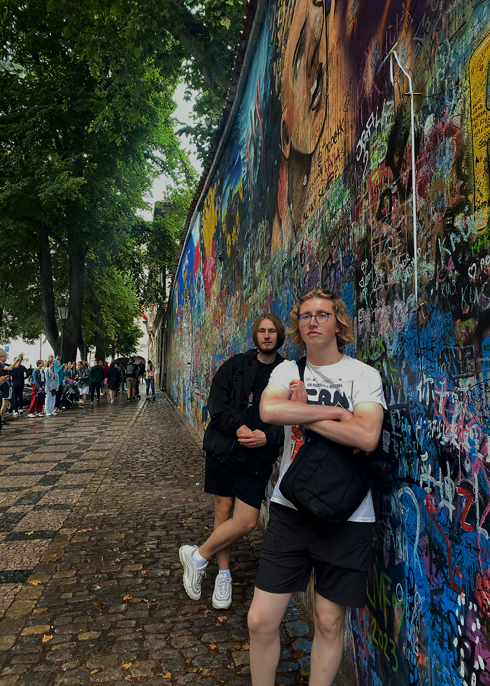 Two students leaning against Lennon Wall in the Little Quarter in Prague