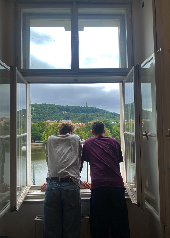 Two male students looking out a window 