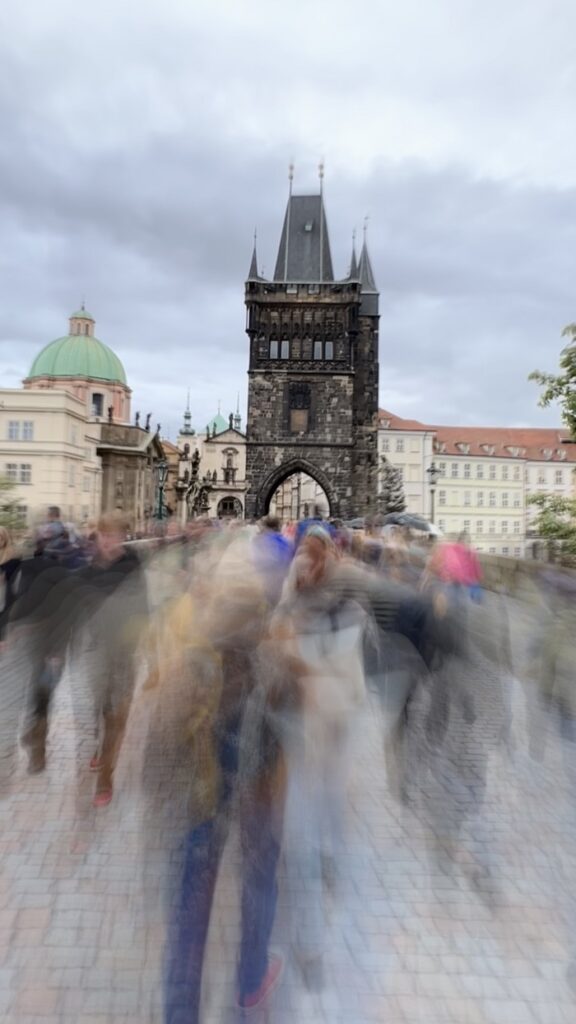 People walking and blurred from the slow camera shutter speed on a street in Prague, Czech Republic