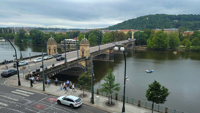 A bridge over water with people and cars crossing it and walking along it