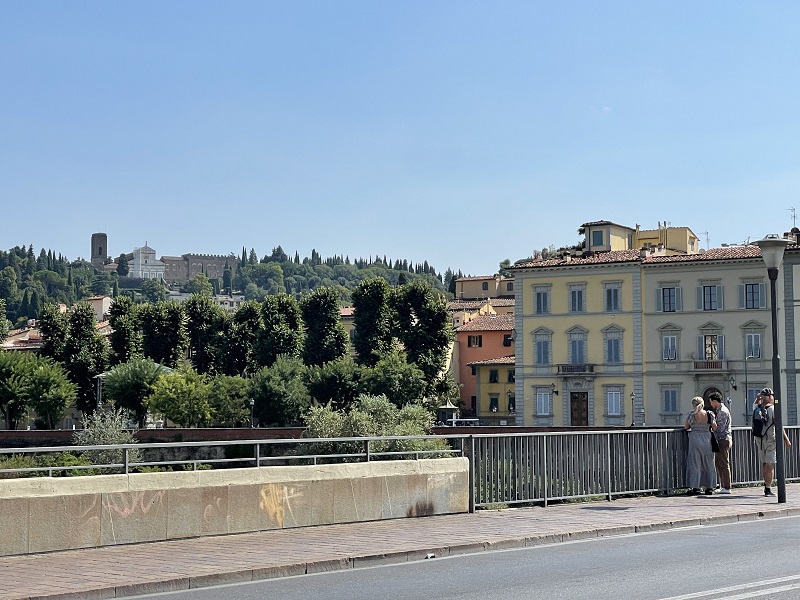 A CET building on the right and the hilltop San Miniato al Monte in the upper left on a clear day in Florence, Italy