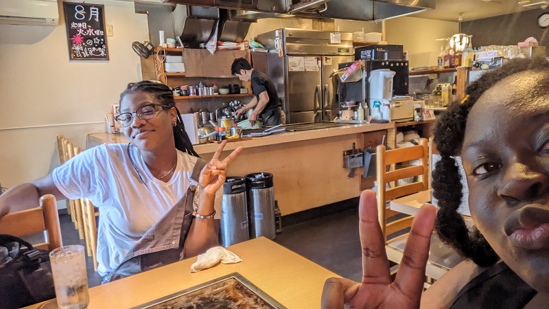 Two CET Japan students eating Okonomiyaki at a restaurant