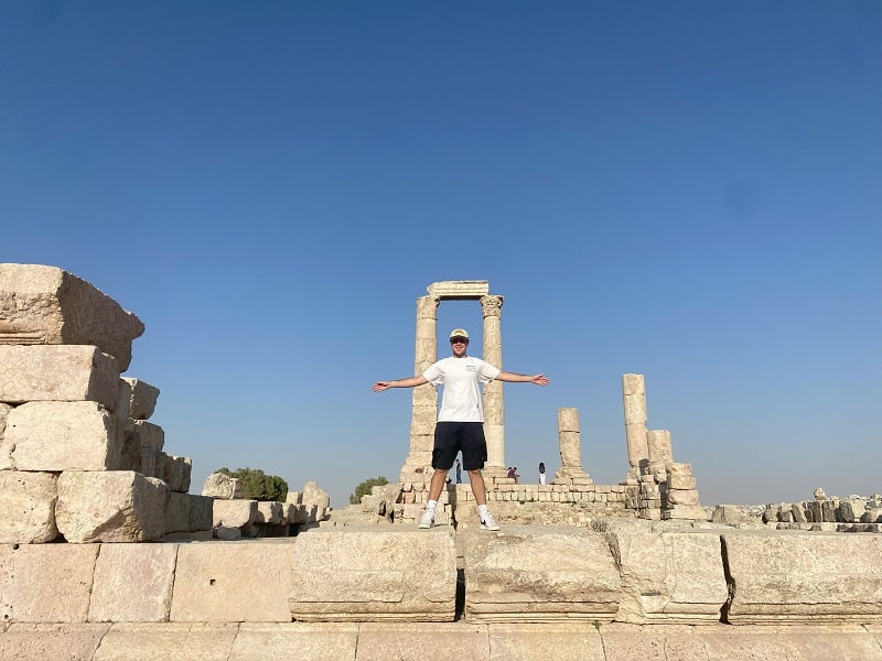 A CET Jordan male student standing in front of the Roman Temple of Hercules at the Amman Citadel