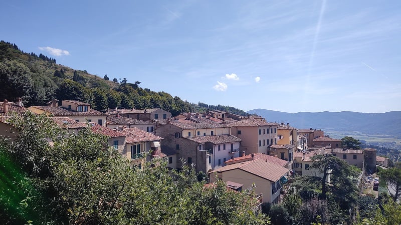 View of Siena homes, greenery, and mountains on the far right on a cloudless day