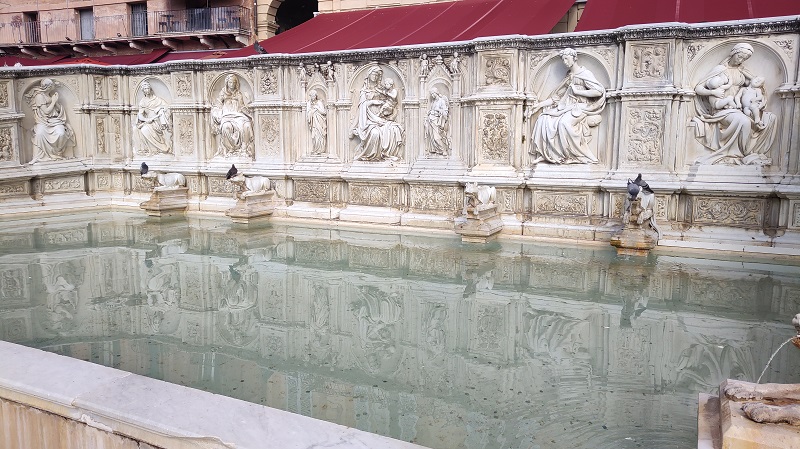 A shallow fountain with water in Siena, Italy