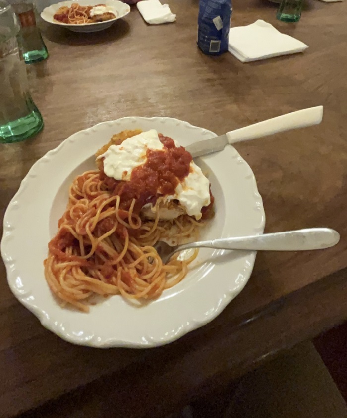 Chicken parmigiana dish with a fork and knife in it