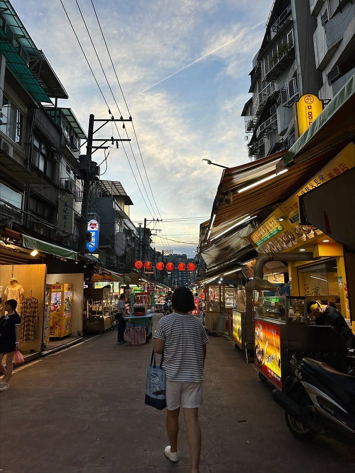 Somebody walking towards the entrance to a night market in Taipei, Taiwan