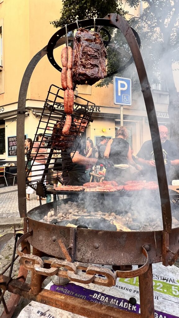 Meats and sausages hanging on an outdoor grill at a Mexican street festival in Prague