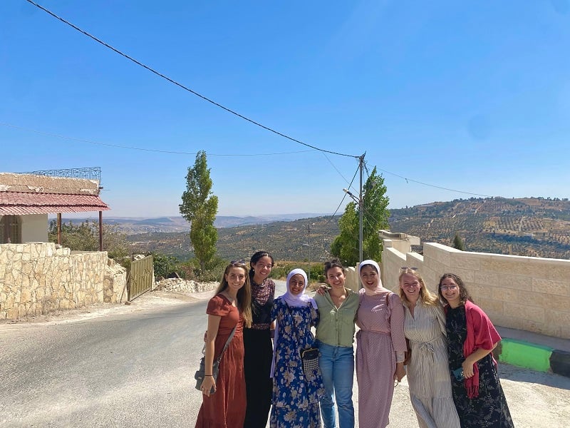 CET Jordan students and their Jordanian neighbors in front of the beautiful countryside