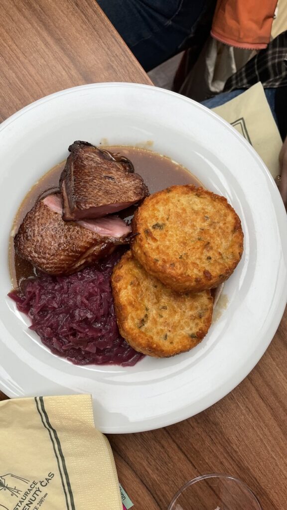 Traditional Czech meal with duck breast, cabbage, and potatoes on a plate