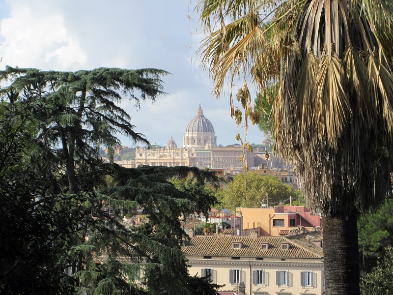 Saint Peter’s Basilica dome peeking through tree branches at the Borghese Gardens