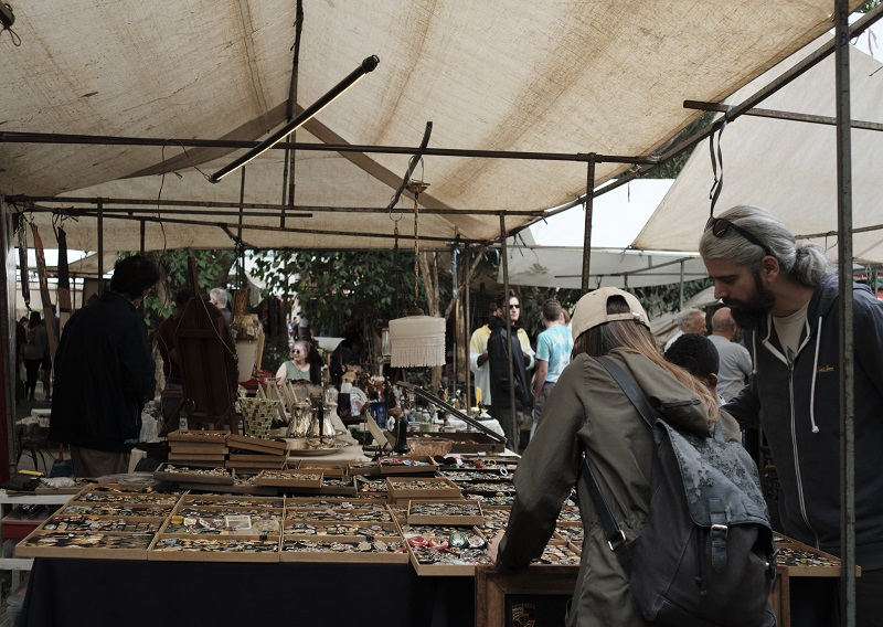 People looking through items on tables at the Arts Fair of Benedito Calixto Square in Brazil