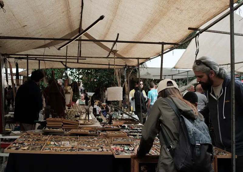 People looking through items on tables at the Arts Fair of Benedito Calixto Square in Brazil