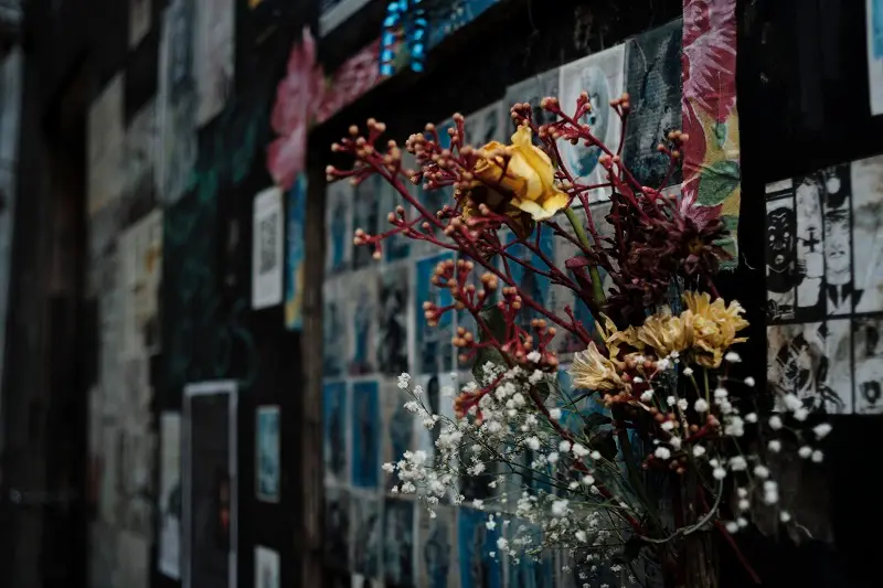 Artwork, writing, and flowers posted near a chapel in São Paulo, Brazil in respect and remembrance of this history