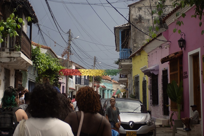 People walking in the middle of the narrow street of Cartagena on a cloudy day