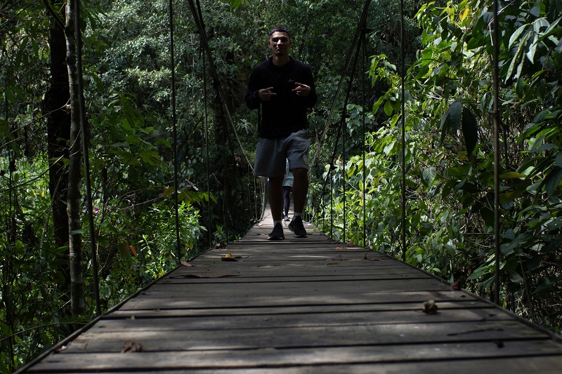 A male CET Colombia student walking across a bridge in Los Farallones de Cali