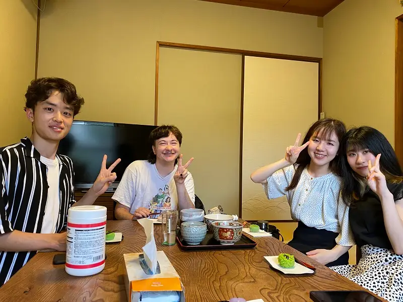 CET Japan and Osaka Gakuin University roommates sitting on the floor at a table with wagashi candies and tea