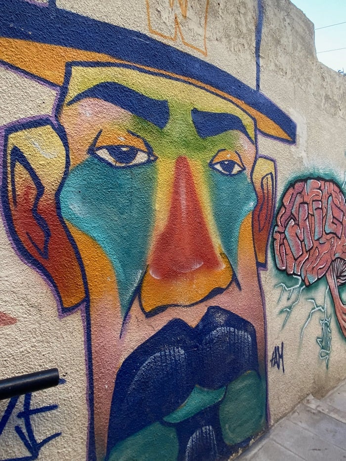 Graffiti wall art of a man's face wearing a hat in Amman, Jordan 