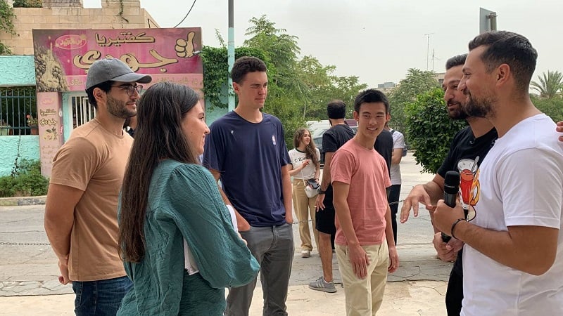 A couple of CET Jordan students talking to two male influencers holding a microphone in the street