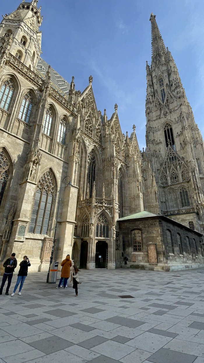 Some people standing outside of St. Stephen's Cathedral in Vienna, Austria