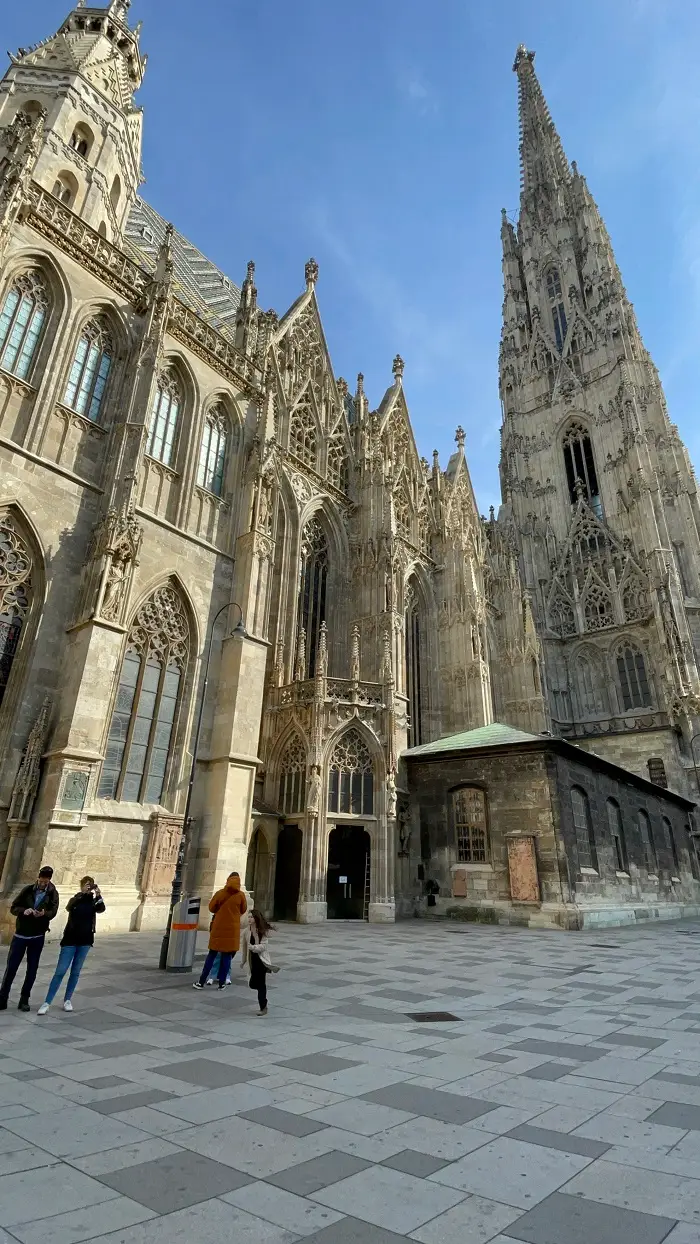 Some people standing outside of St. Stephen's Cathedral in Vienna, Austria