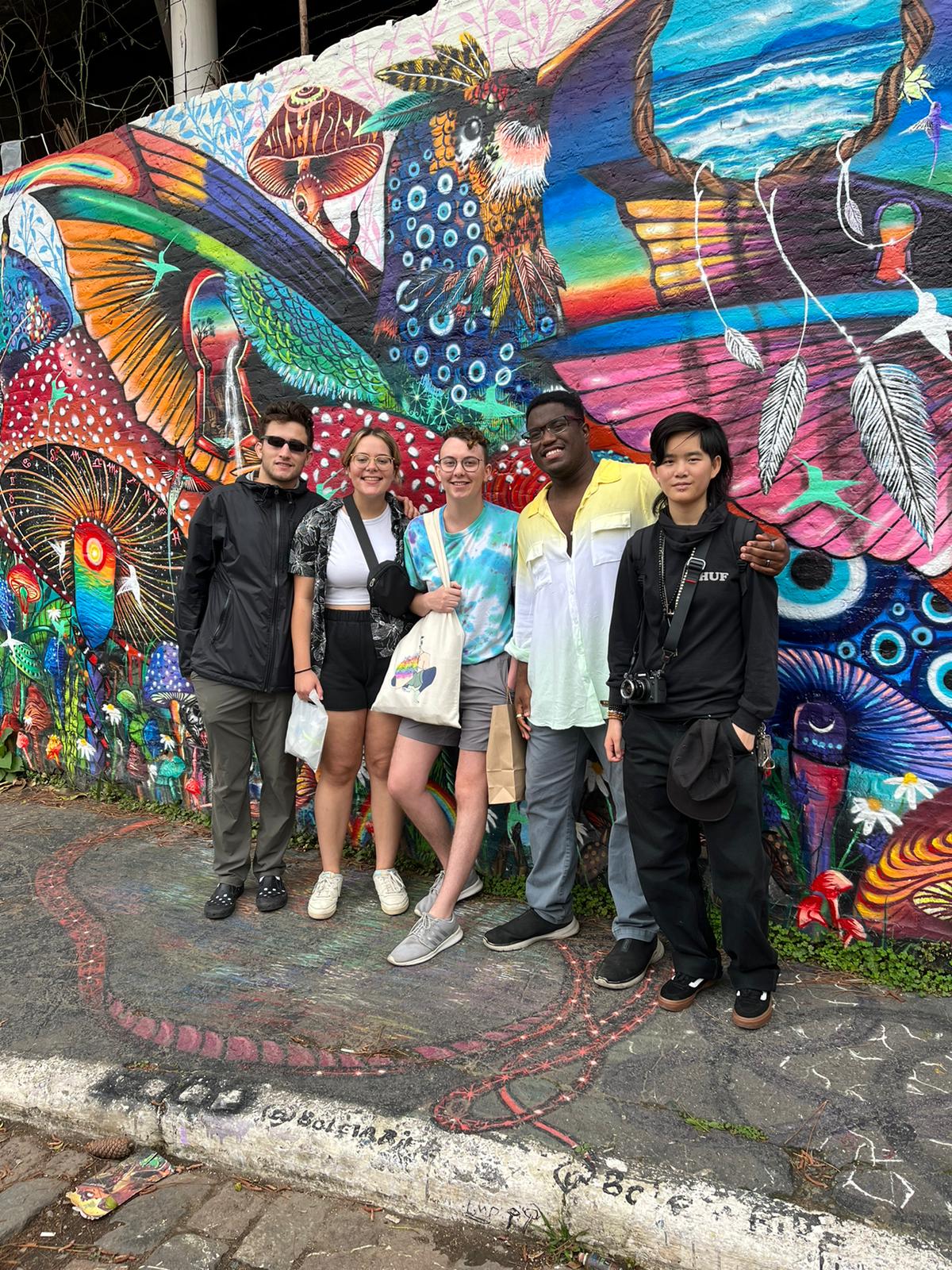 Five CET Brazil Social Justice students standing by wall art in Brazil