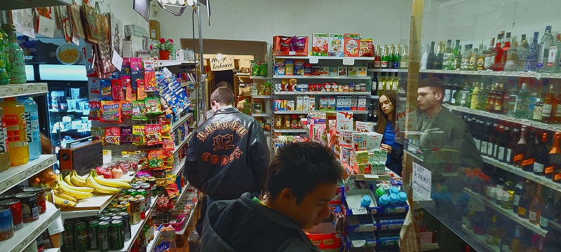 Some people checking out items throughout a minimart in Prague