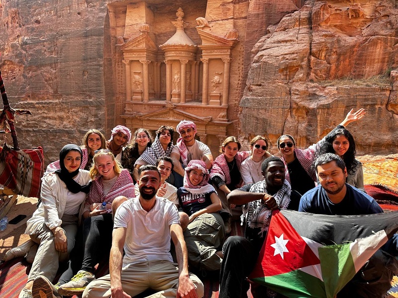 CET Jordan students sitting and smiling by Petra in Jordan