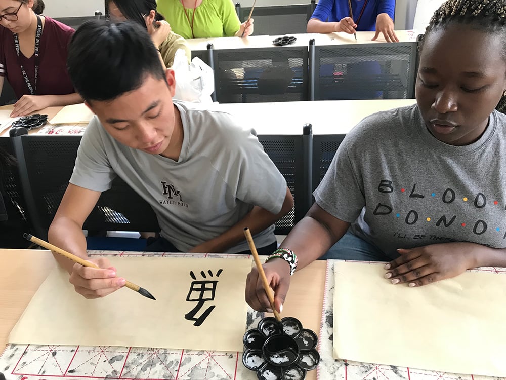 students working on traditional calligraphy