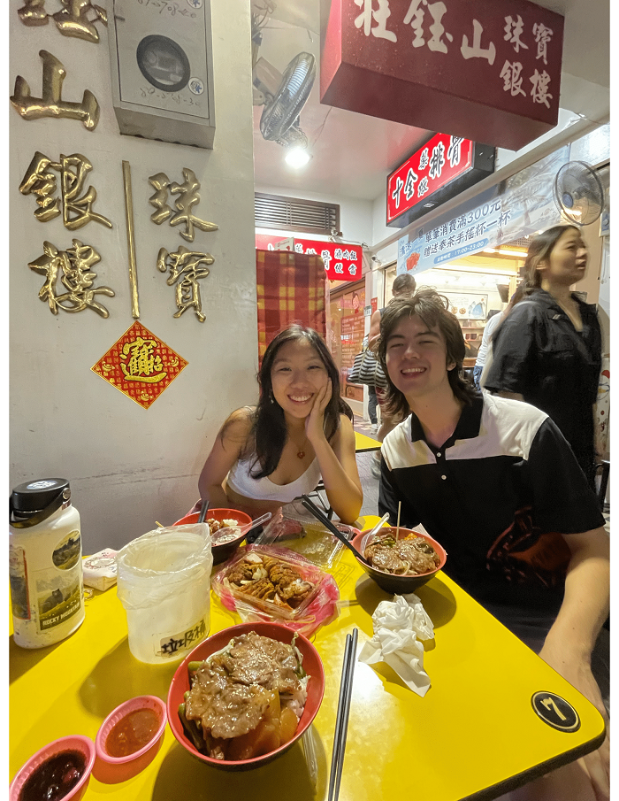 Two CET Taiwan students smiling in front of an array of food in Taiwan