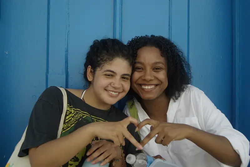 A CET Social Justice student her Brazilian roommate make a heart sign with their hands