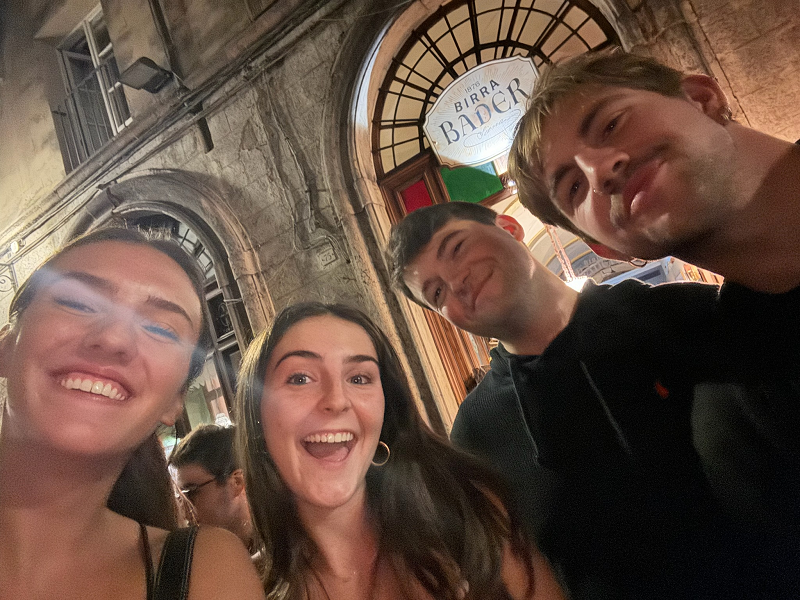 A group photo of four people out in the streets of Siena, Italy