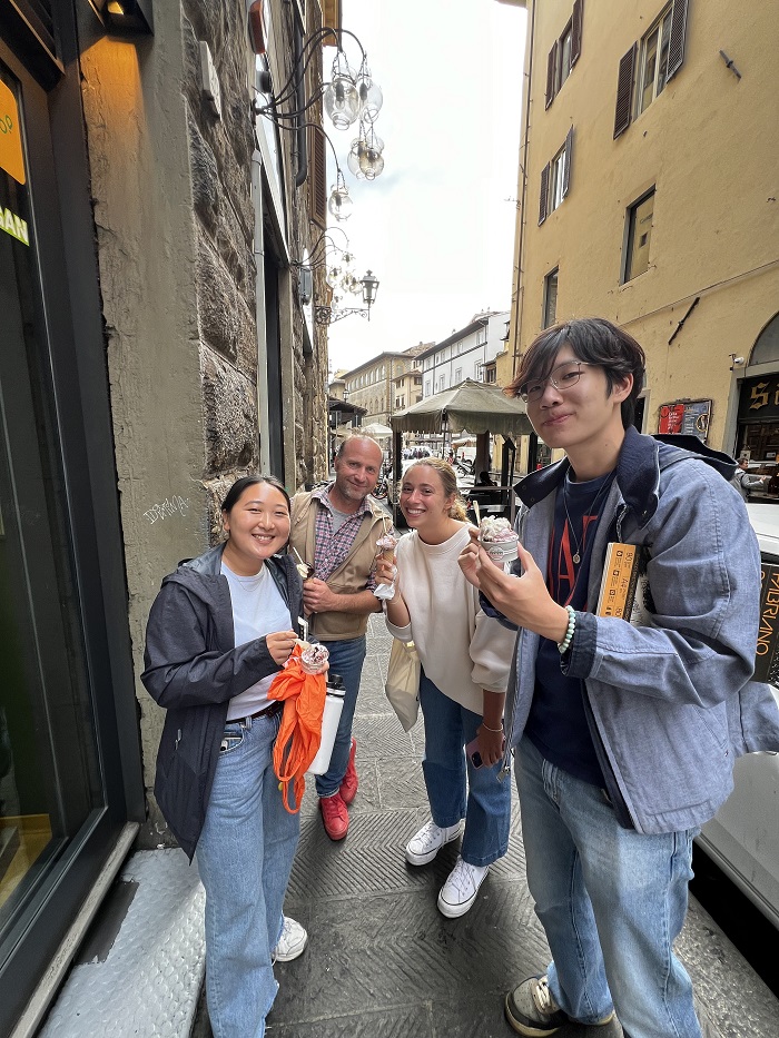 Three CET Florence students and their professor holding cups of gelato outside