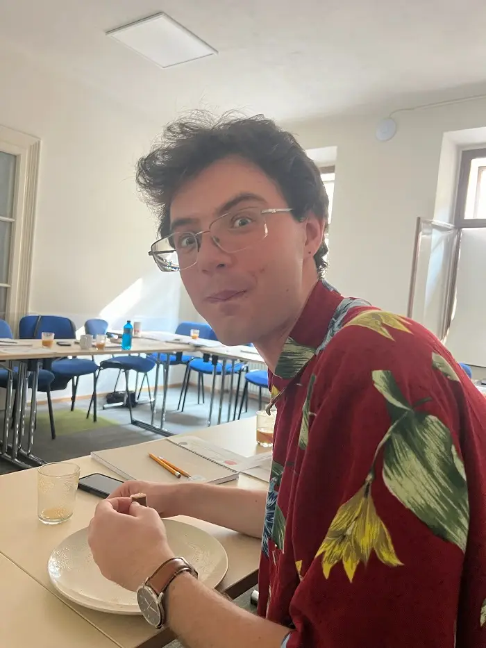 A CET Prague student sitting in a classroom trying honey