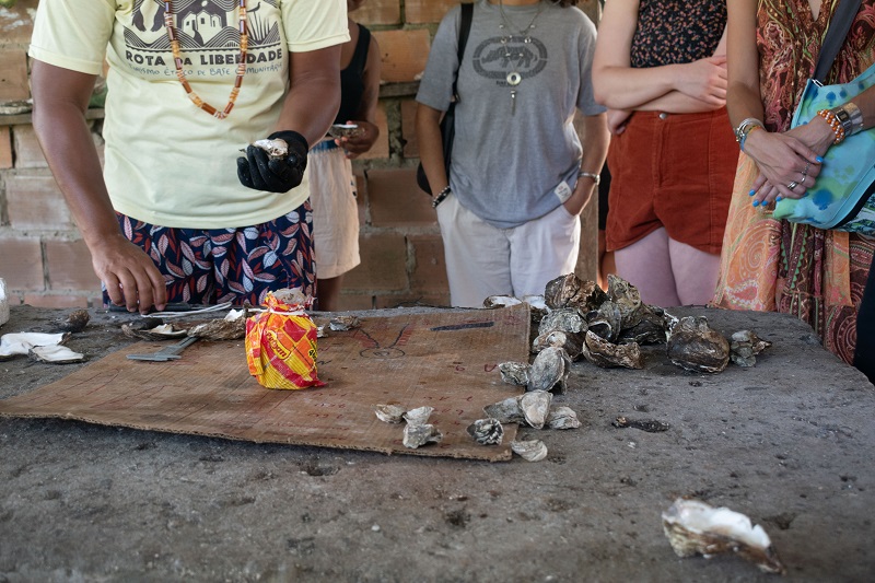 A group of people standing around a table with harvested oysters