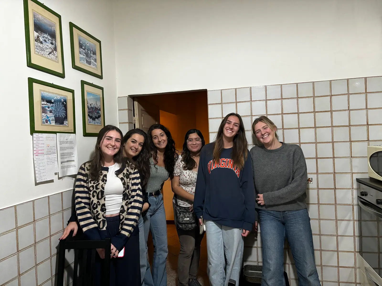 A group photo of CET Siena students and local roommates in their apartment kitchen