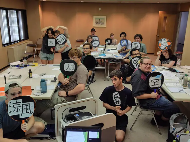 students in classroom holding fans