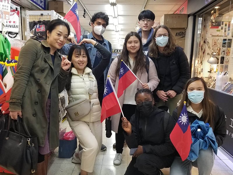 group of staff and students holding flags