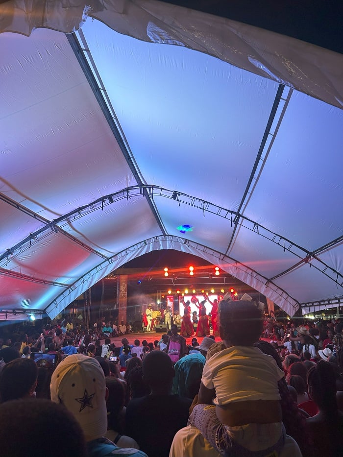 Performers on a stage and a large crowd watching a drum ceremony in San Basilio de Palenque