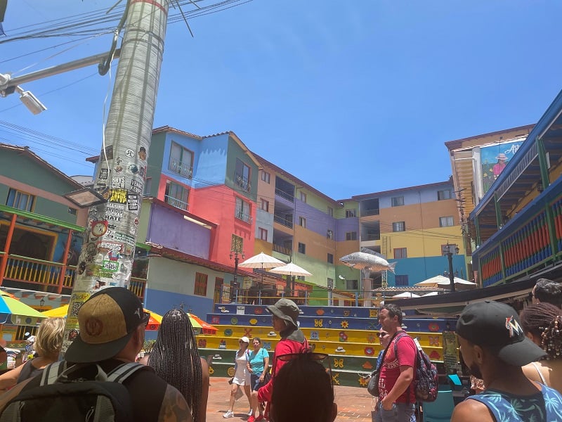 The small town of Guatape and people walking around the colorful buildings on a cloudless day