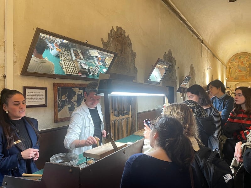 A group of CET Florence students watching staff inside a leather shop called Scuola di Cuoio in Italy