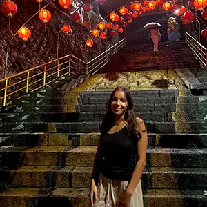 student standing under lanterns