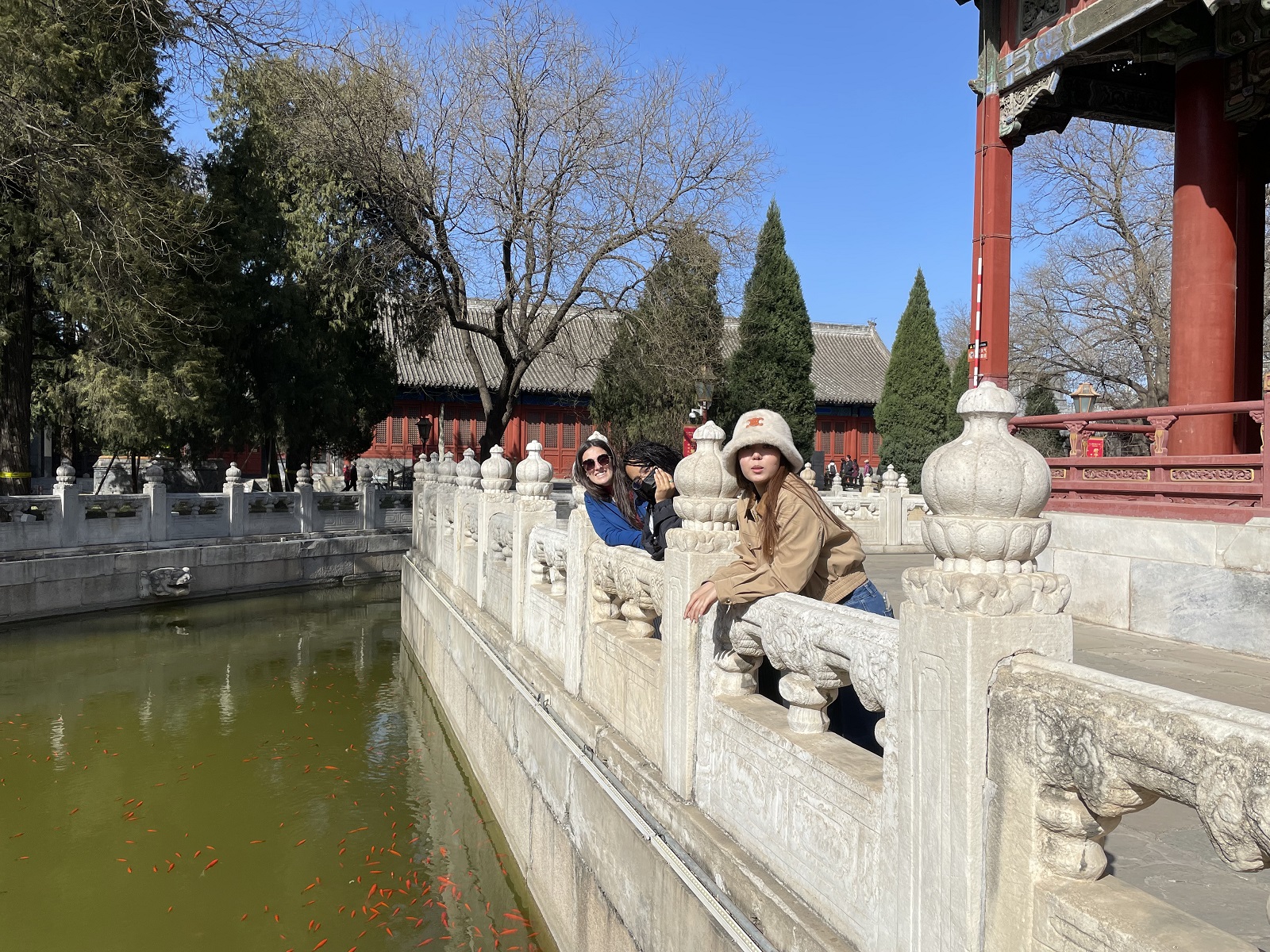Two students looking at the camera while leaning over a ledge within the Temple of Confucius in Beijing
