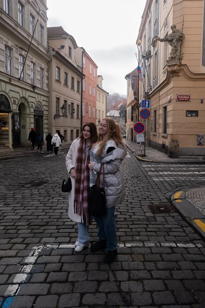 Two CET Prague students smiling and posting in the middle of a street