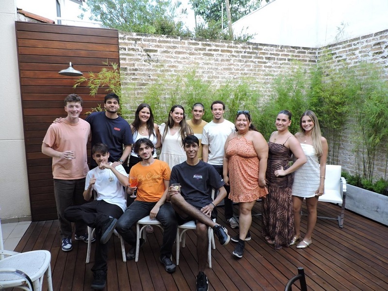 A large group posing together while standing and sitting outside in a courtyard
