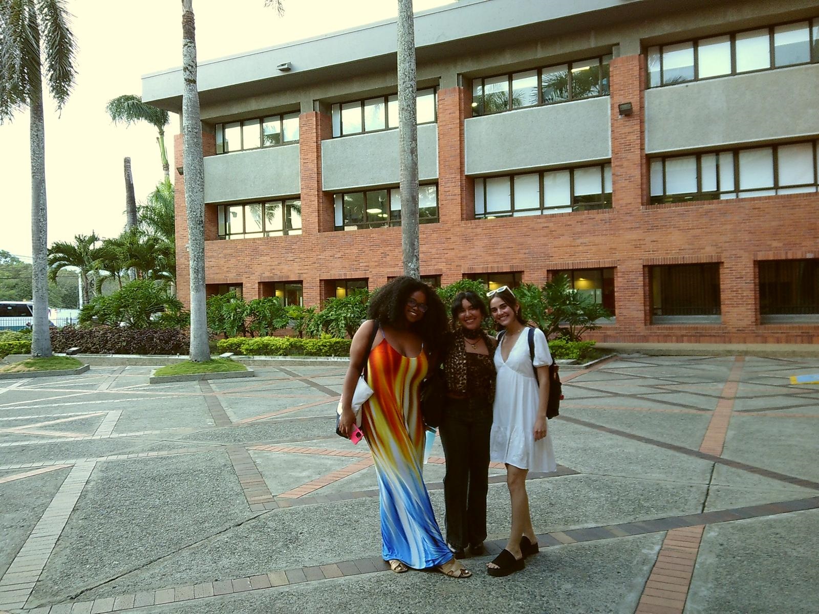 Three CET Colombia students posing and smiling together in front of La Universidad Autónoma del Occidente in Cali, Colombia
