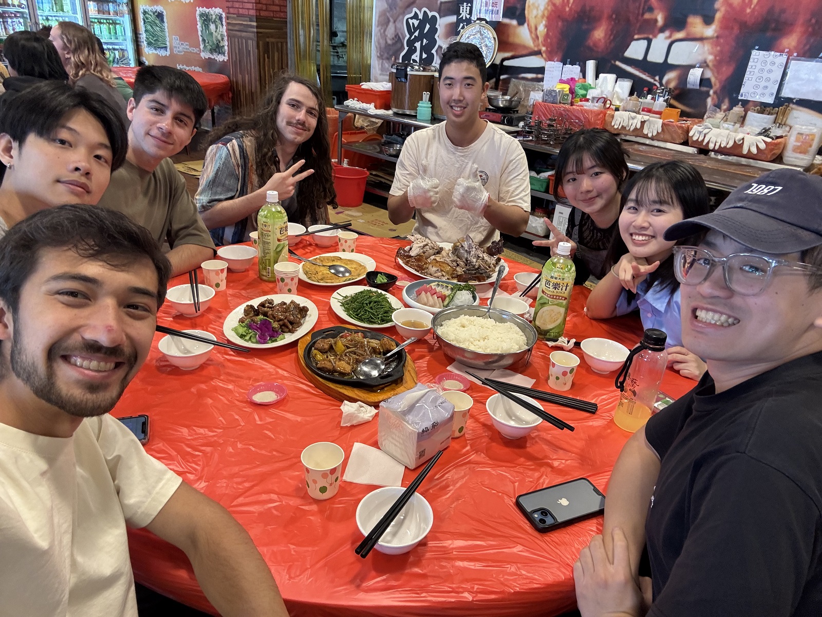 A table with a mixture of Taiwanese local roommates and CET students with plates of food