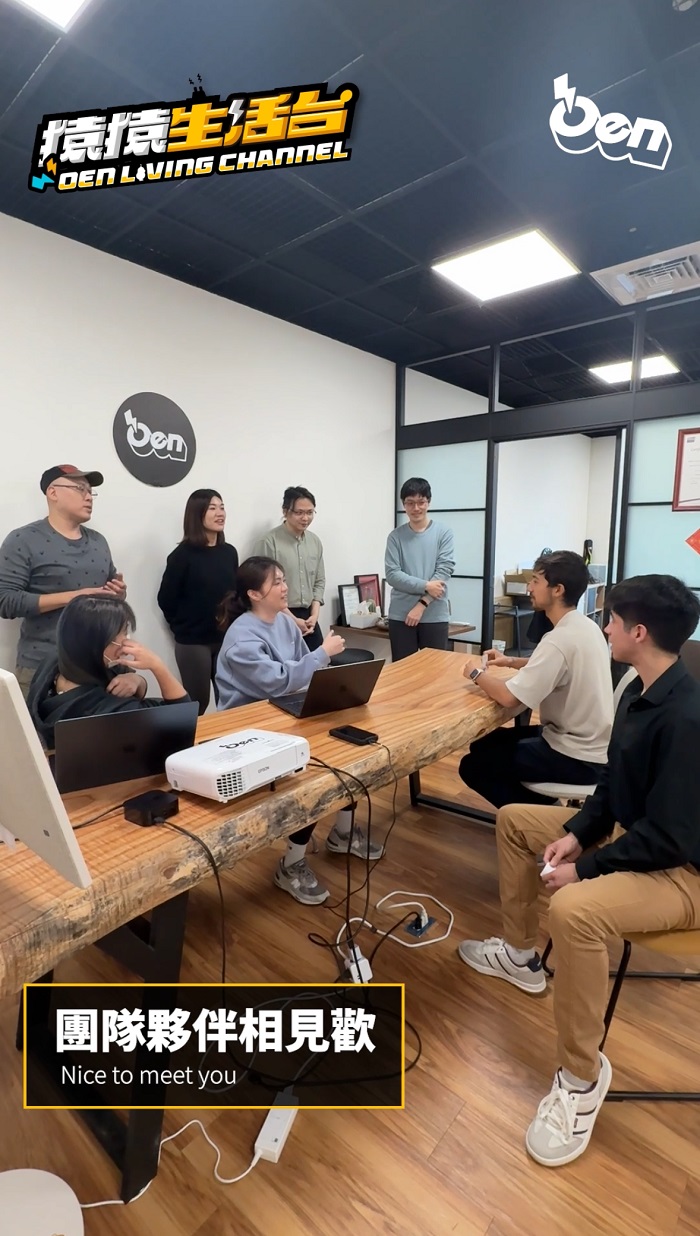 A group of workers at Oen Tech company in Taiwan sitting around a table with laptops and a projector