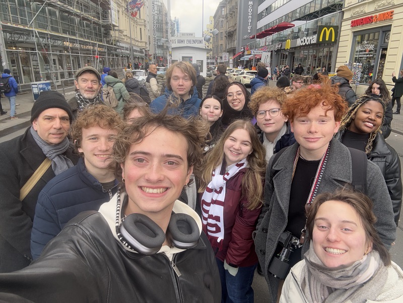 A group of CET Film Production at FAMU students and staff taking a group selfie in the middle of a street in Berlin while on a walking tour